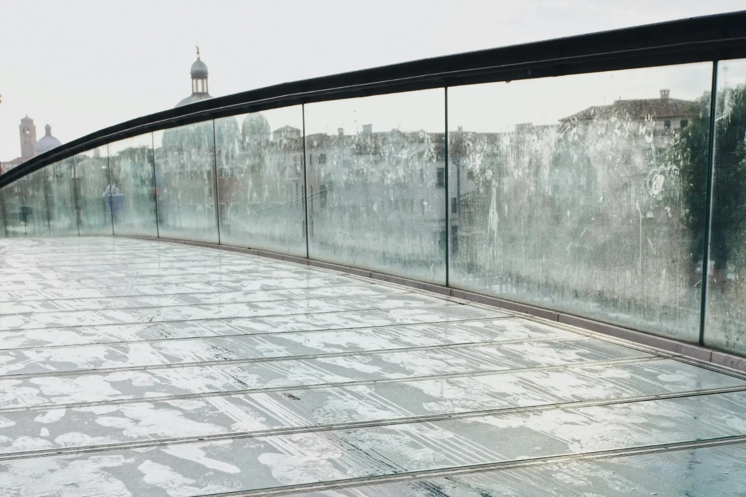 Moderne Glasbrücke mit strukturiertem Glasboden und rahmenlosem Glasgeländer.
